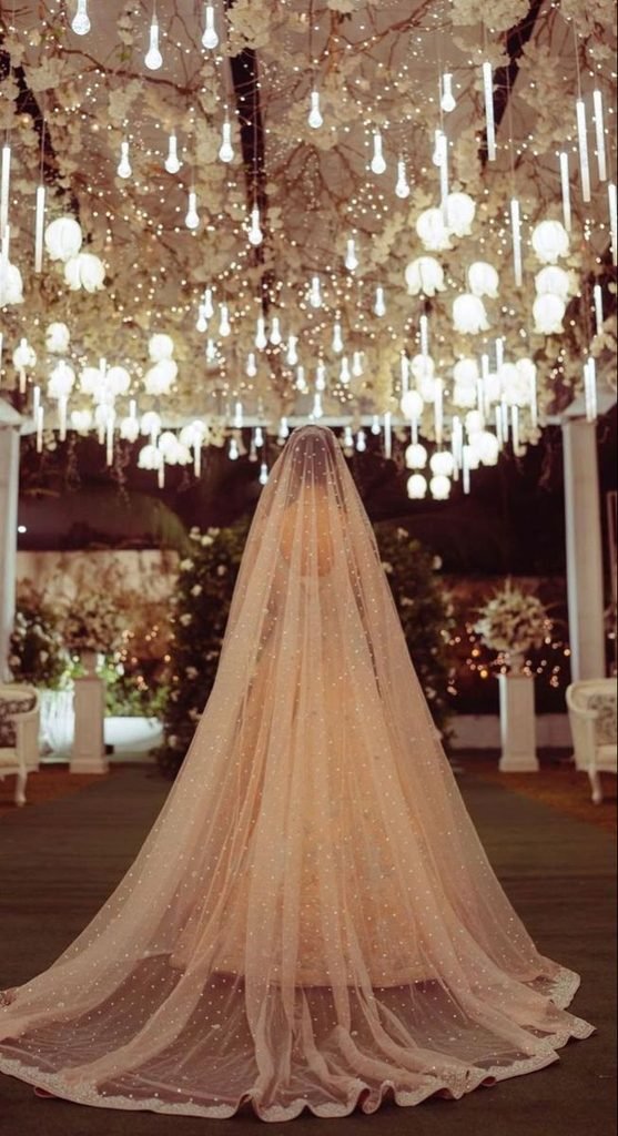 Bride wearing a delicate ivory veil or embroidered bridal dupatta with a timeless wedding outfit.